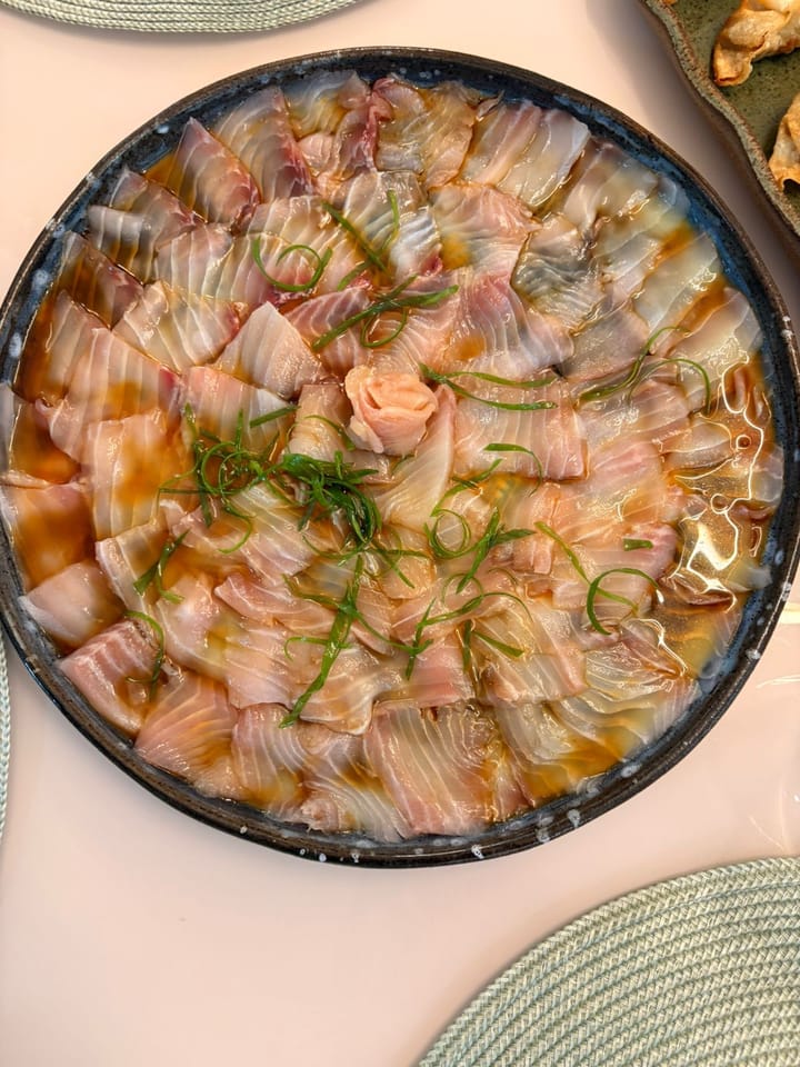 Carpaccio de peixe branco em espiral com flor de gengibre ao centro